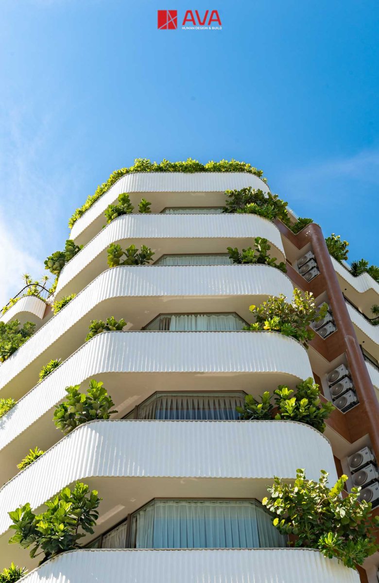 Ban công và cây xanh trên mặt đứng Aries Building]